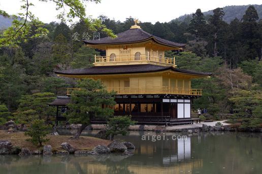 黄色二层寺庙,四周树木环绕(yellow 2-storey temple surrounded by